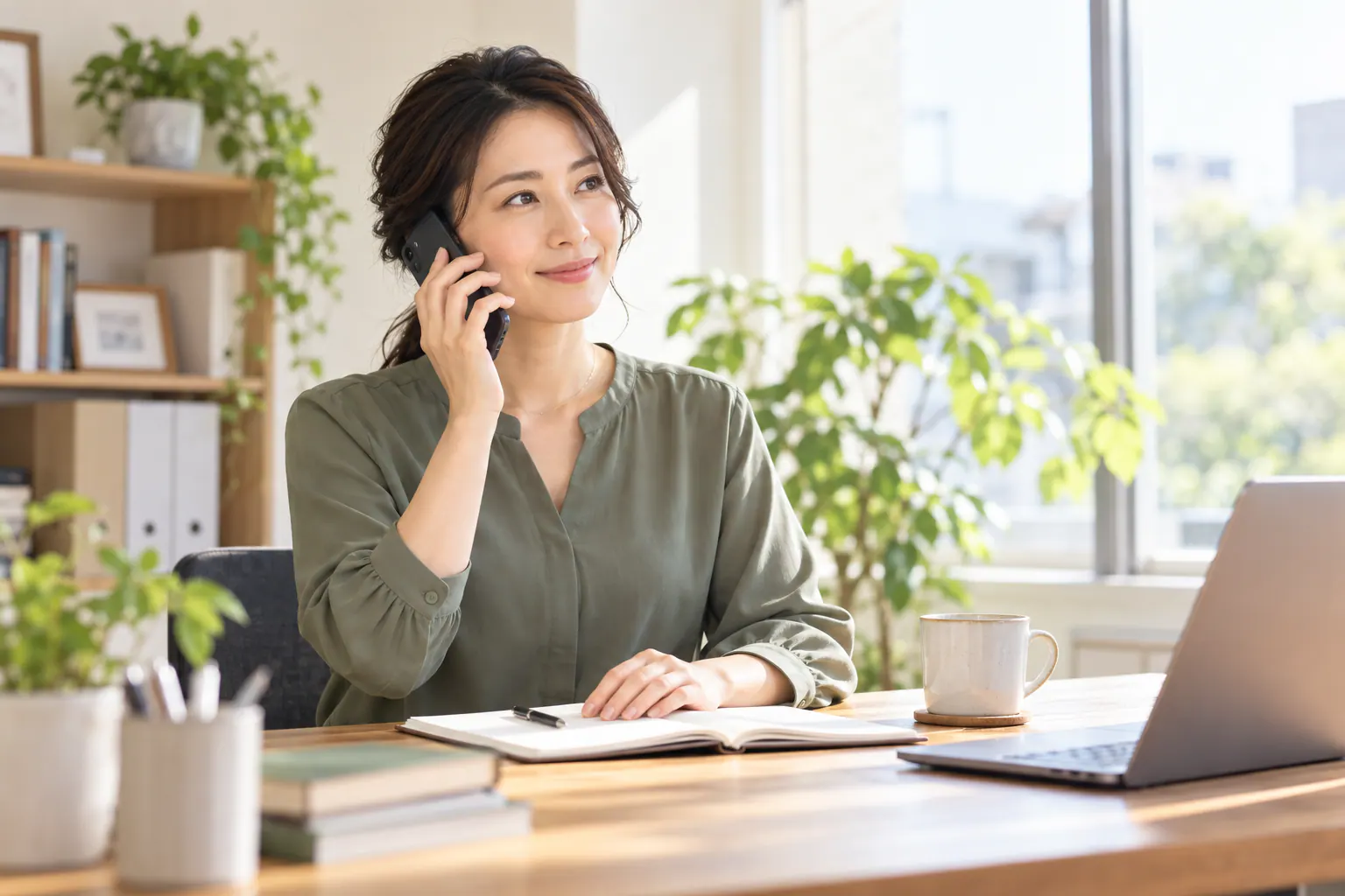 静かなオフィスでスマートフォンを耳に当てて電話を聞く会社員